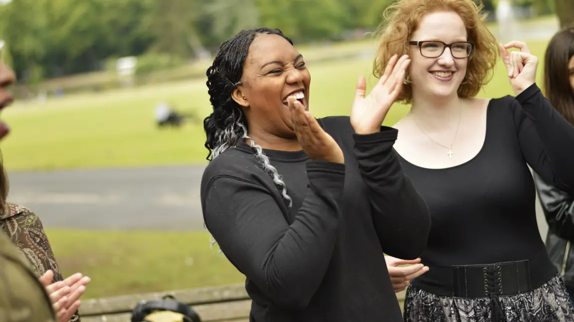 Young people clapping and laughing in the sun