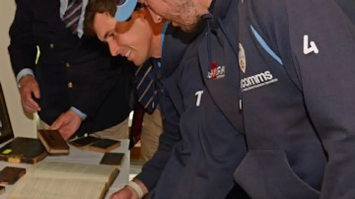 Players from Derbyshire County Cricket Club examine the exhibits