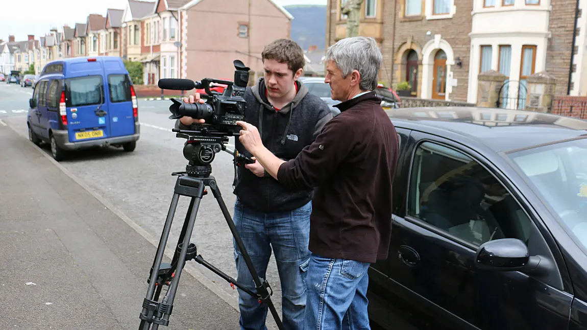 One of the young people sets up his camera