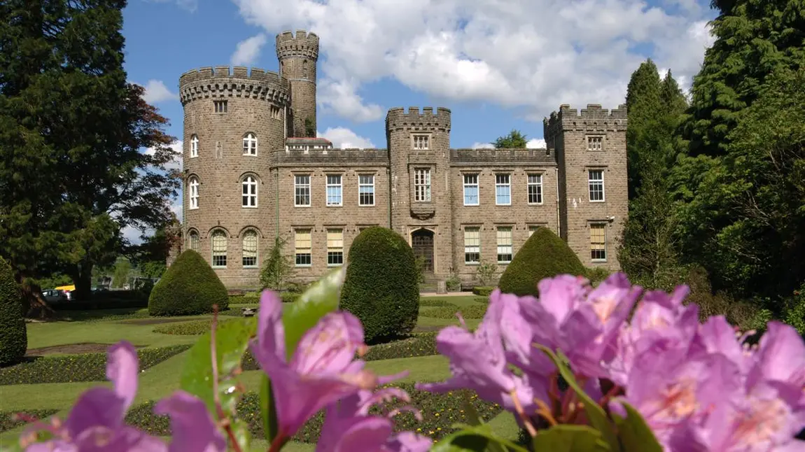 Heritage building surrounded by flowers in Cyfarthfa Park, South Wales