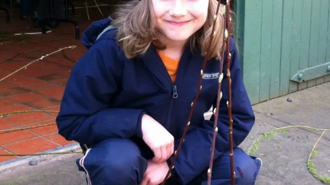 A young person taking part in willow weaving 