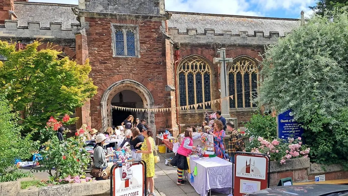 a market outside a historic brick church in summer